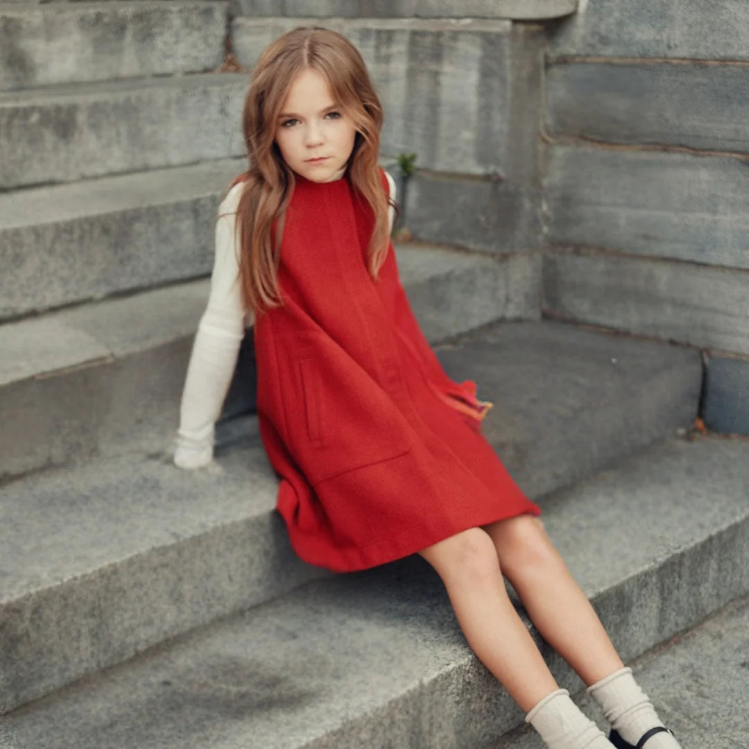 A child wearing the Cottier crimson jumper sitting.