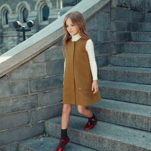 A child wearing the Cottier mustard jumper during an autumn.