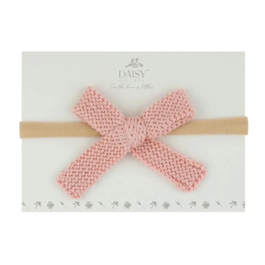 A flat-lay view of the Daisy Gift Box knit flat bow headband in rose.
