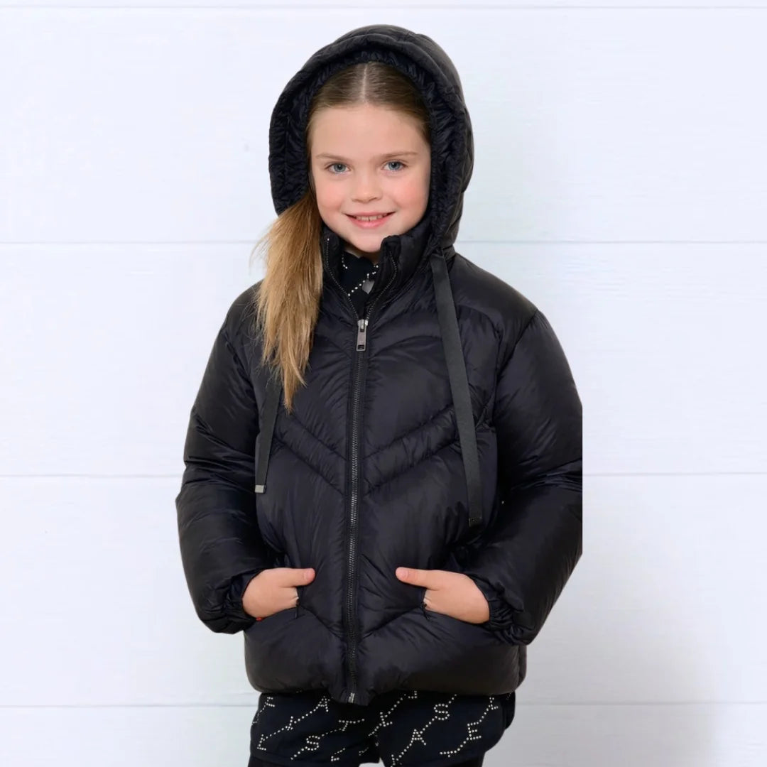 A child wearing the Denali black heart-quilted coat comfortably 
