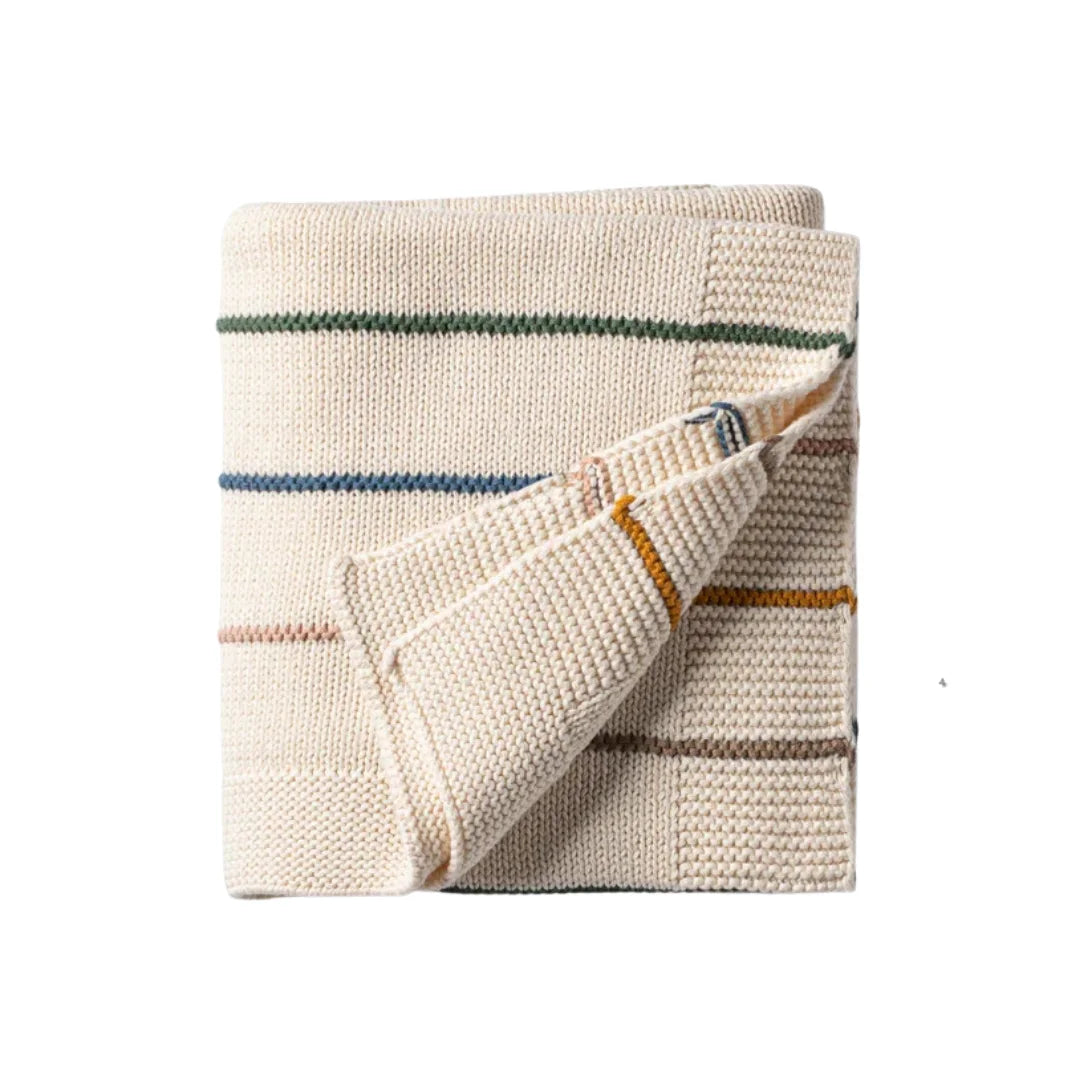A folded cream-colored knit blanket with thin horizontal stripes in green, blue, orange, and brown, shown on a plain white background.