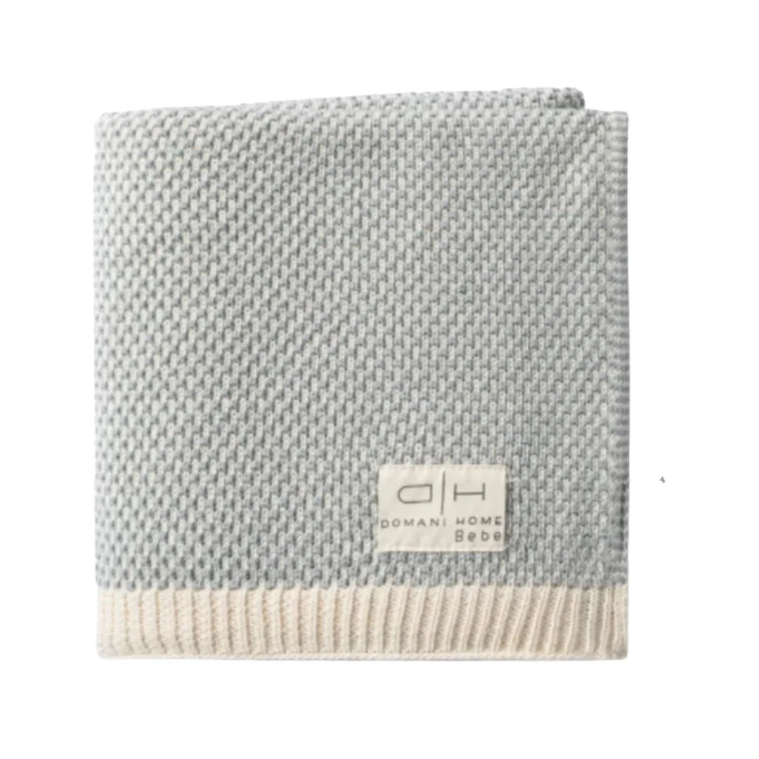 A three-piece baby bedding set featuring a footed sleeper, a beanie, and a blanket, all with matching light pink and white horizontal stripes, laid out on a solid white background.