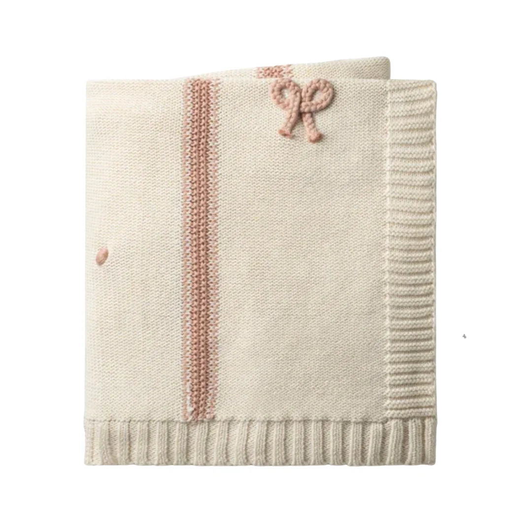 A folded cream-colored knit blanket featuring a vertical dusty pink textured stripe, a matching pink knotted bow detail, and a ribbed border, shown against a plain white background.
