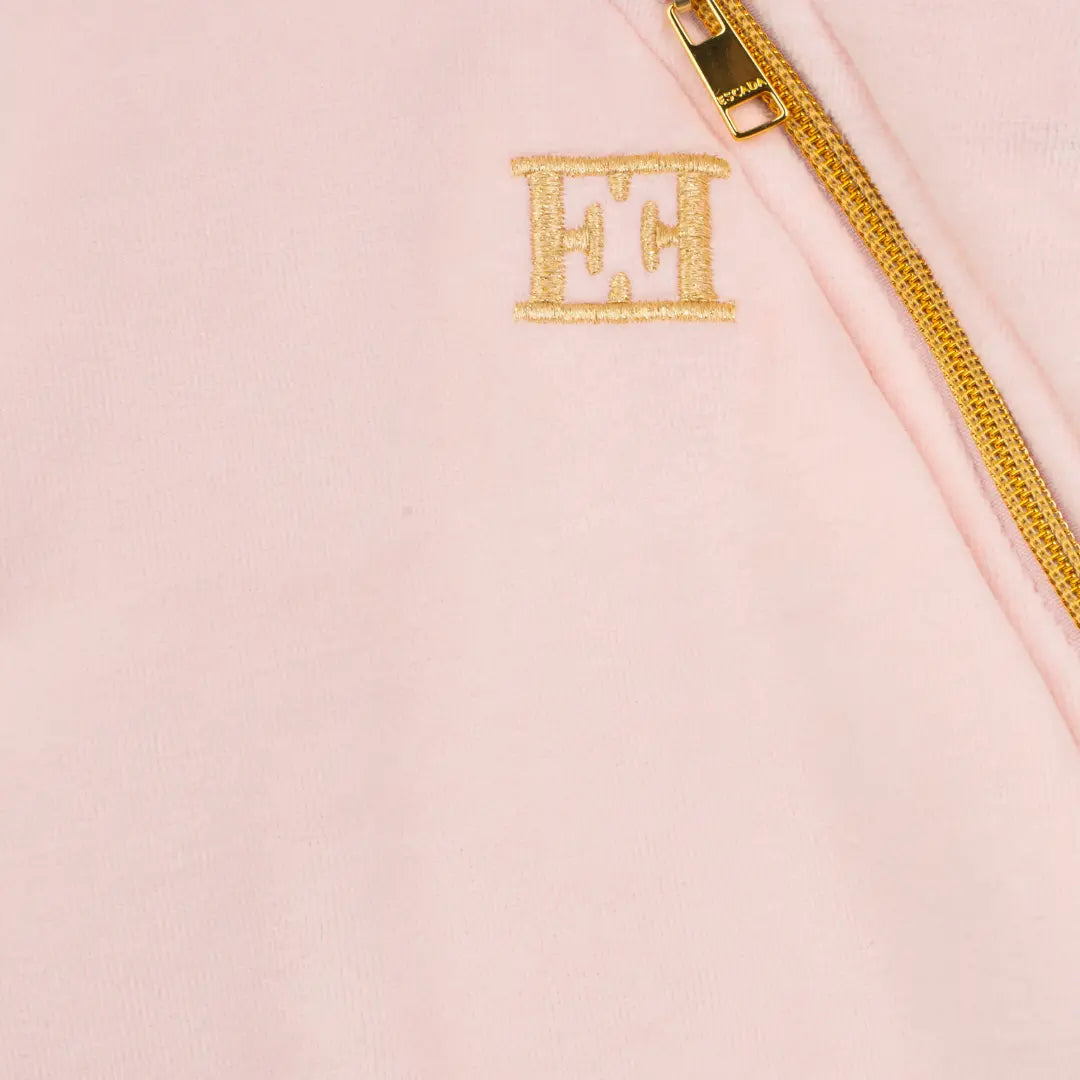 Pink pouch with gold zipper and initials 'EH' on a light pink background