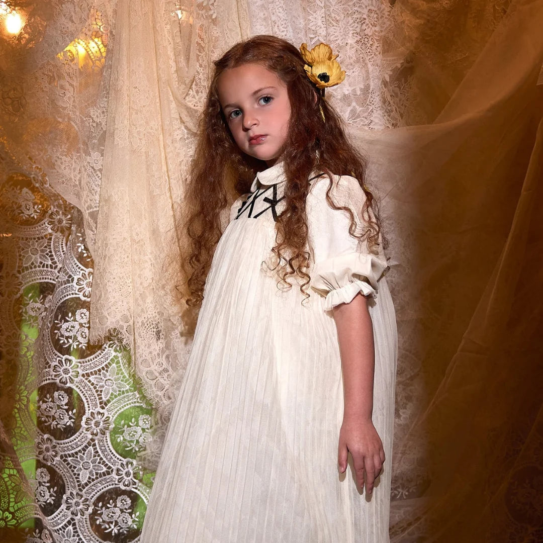 A child wearing the Francesca Guiliano formal dress gracefully during a celebration.