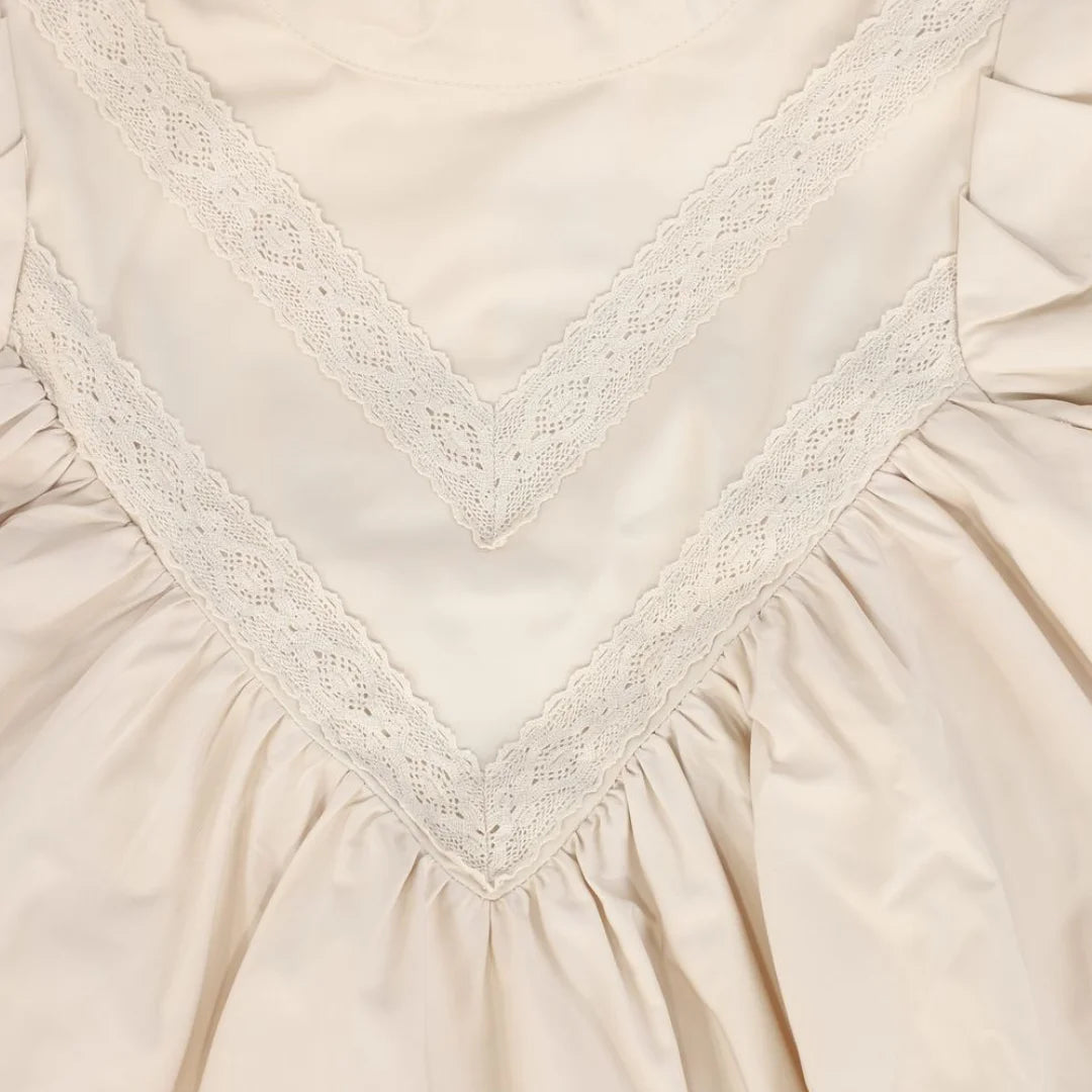 A high-resolution close-up of the crisp taffeta texture and intricate lace V-pattern.