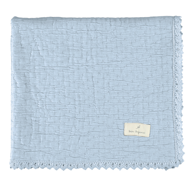 Light blue textured blanket with a brand label on a white background