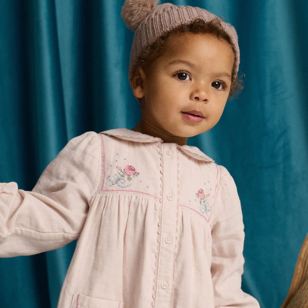 A toddler enjoying a day out while wearing her Gingersnaps Lottie dress.