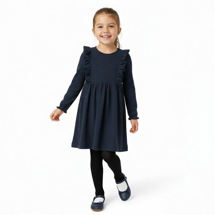 Young girl wearing a navy dress with ruffled sleeves on a white background