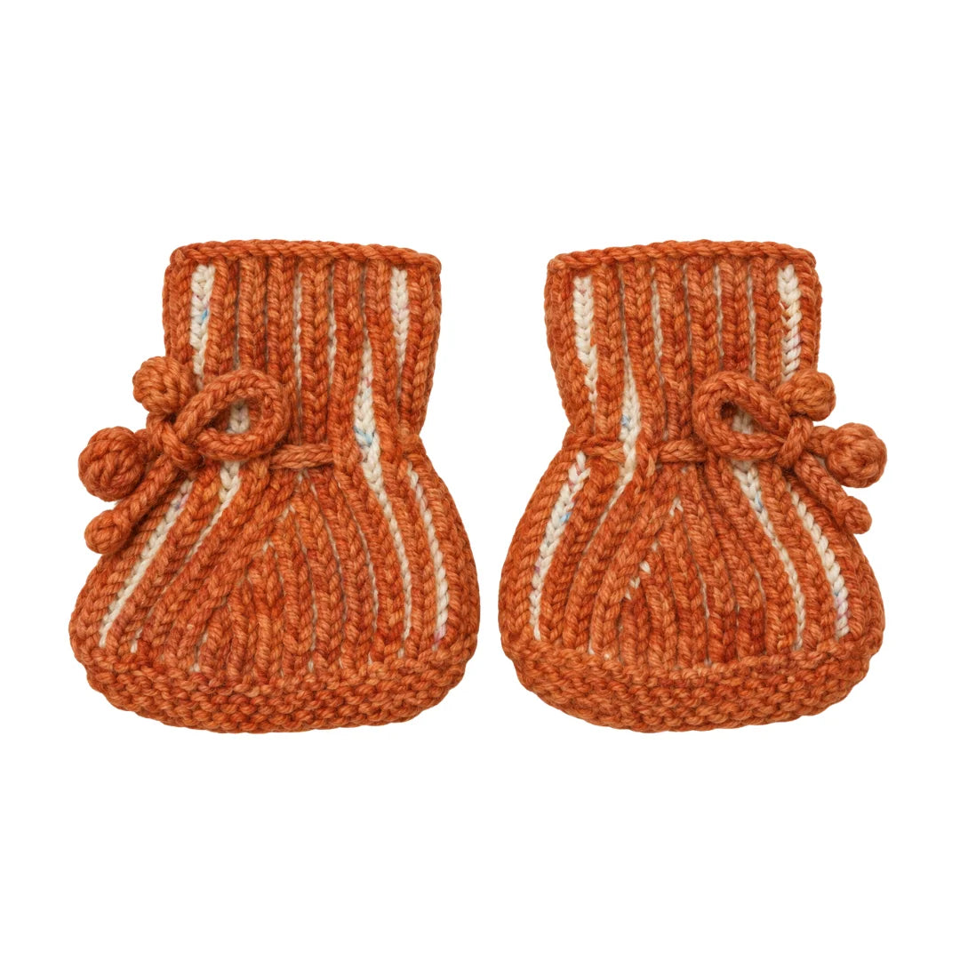 A flat-lay view of the hand-knit ribbed booties in cream toasted.