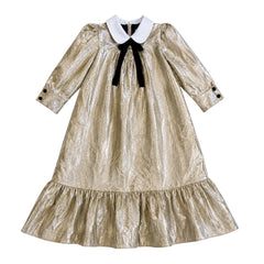 Gold metallic dress with a black bow and white collar on a white background