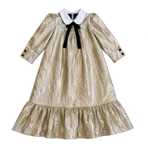 Gold metallic dress with a black bow and white collar on a white background