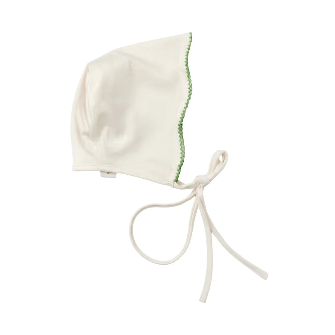 A flat-lay view of the La Mascot picot trim bonnet in white and green.