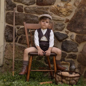 A child wearing the La Nina brown boys pinstripe formal set comfortably during a special celebration.