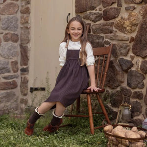 A child wearing the La Nina brown pinstripe jumper set comfortably during an outdoor outing.