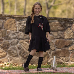A toddler wearing the La Nina taffeta dress during a holiday portrait session.