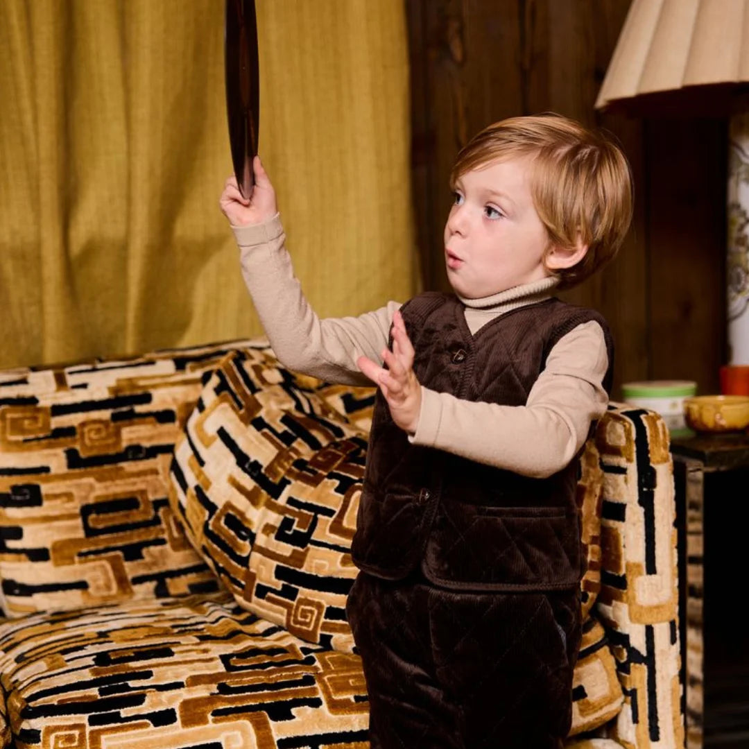 A child wearing the Le Bourdon quilted vest playing