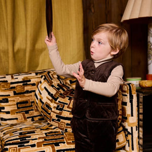 A child wearing the Le Bourdon quilted vest playing