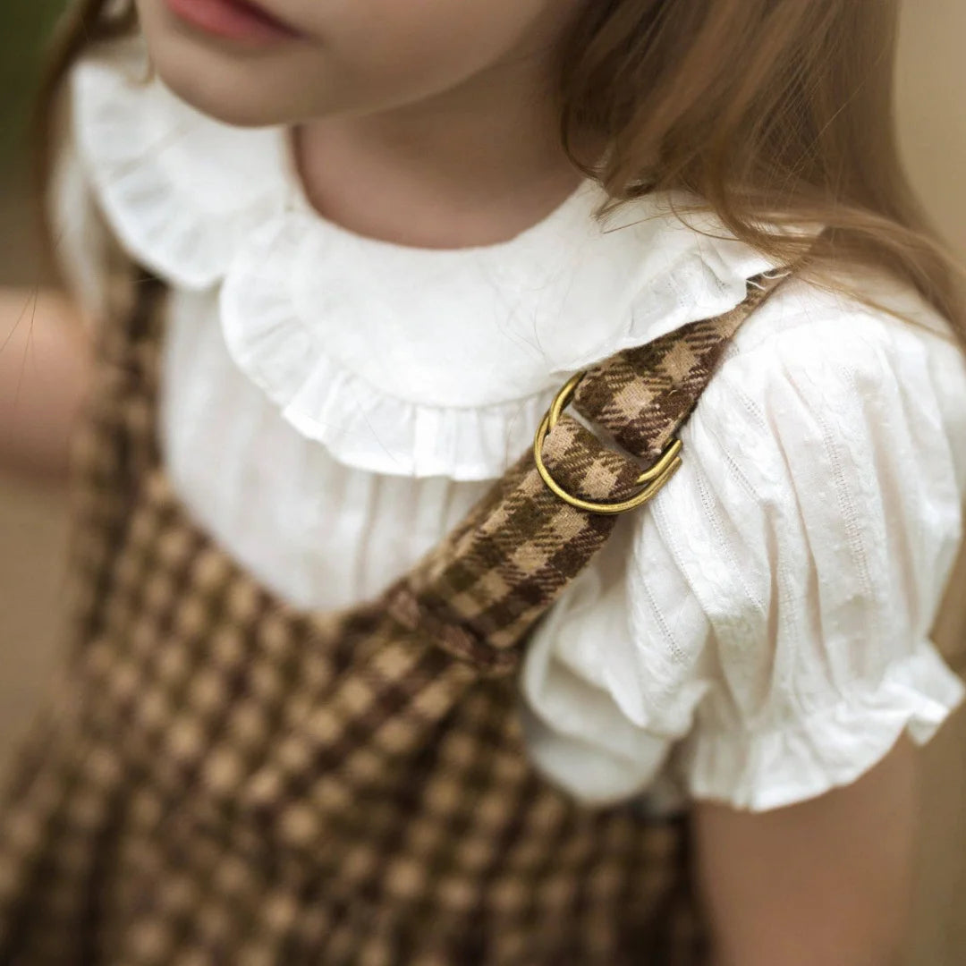 A high-resolution close-up of the cotton gingham fabric texture and warm oak color.