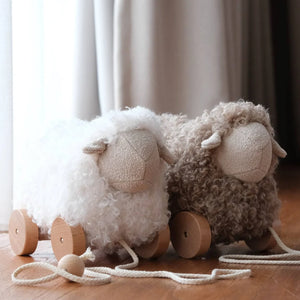 A breathtaking Little Lamb Kind Bella pull-along sheep featuring an immaculate cream fluffy body and smooth wooden wheels.
