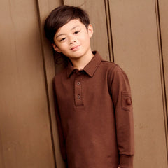 A front view of the Little Parni boy's pocket sleeve polo in brown.