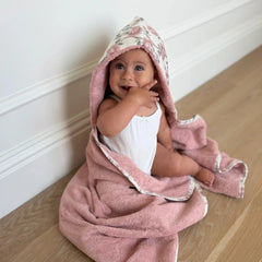A front view of the soft, blush-colored Little Threads Meadow hooded bath towel.