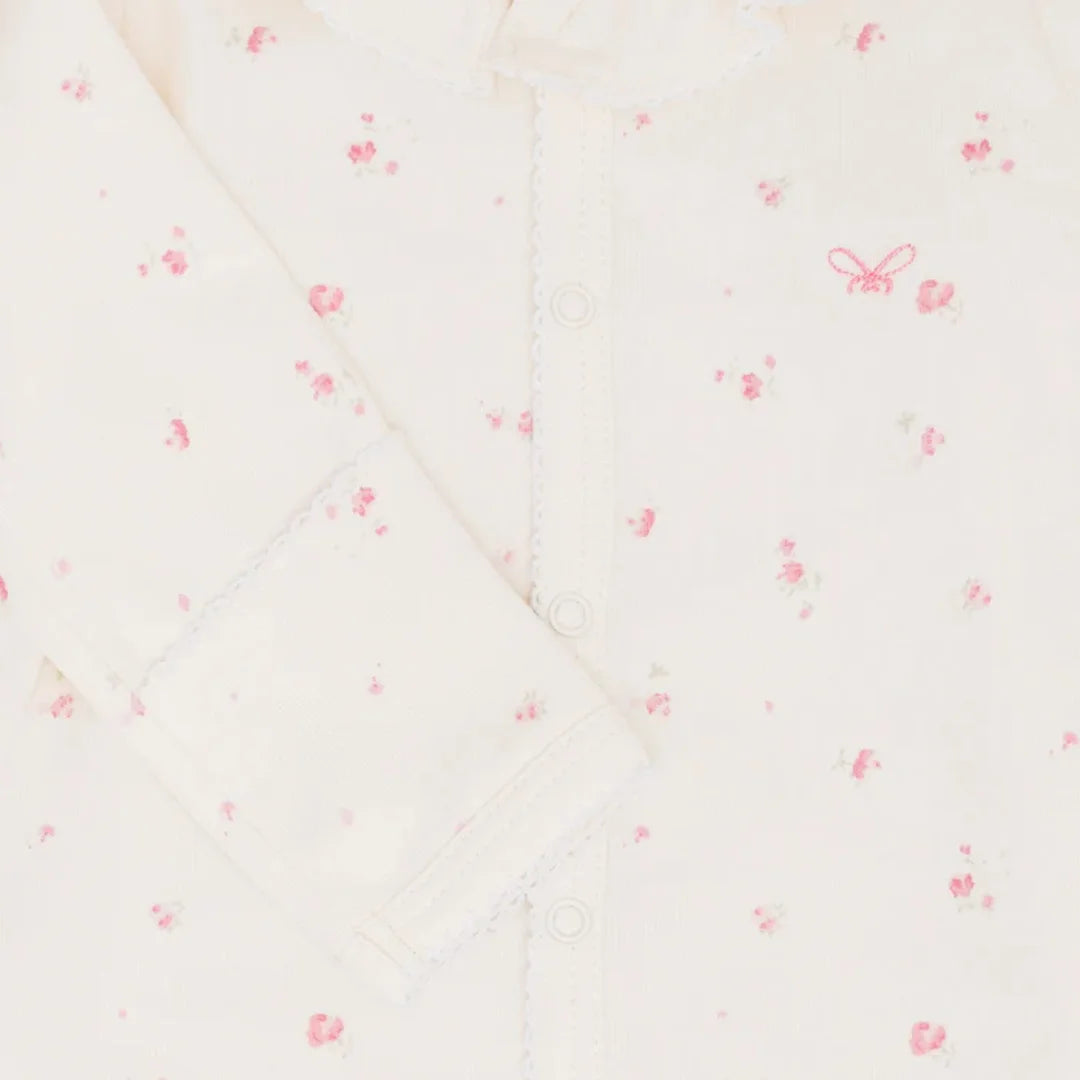 A high-resolution close-up of the delicate ruffled collar and Rose Garden print.