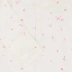 A high-resolution close-up of the delicate ruffled collar and Rose Garden print.