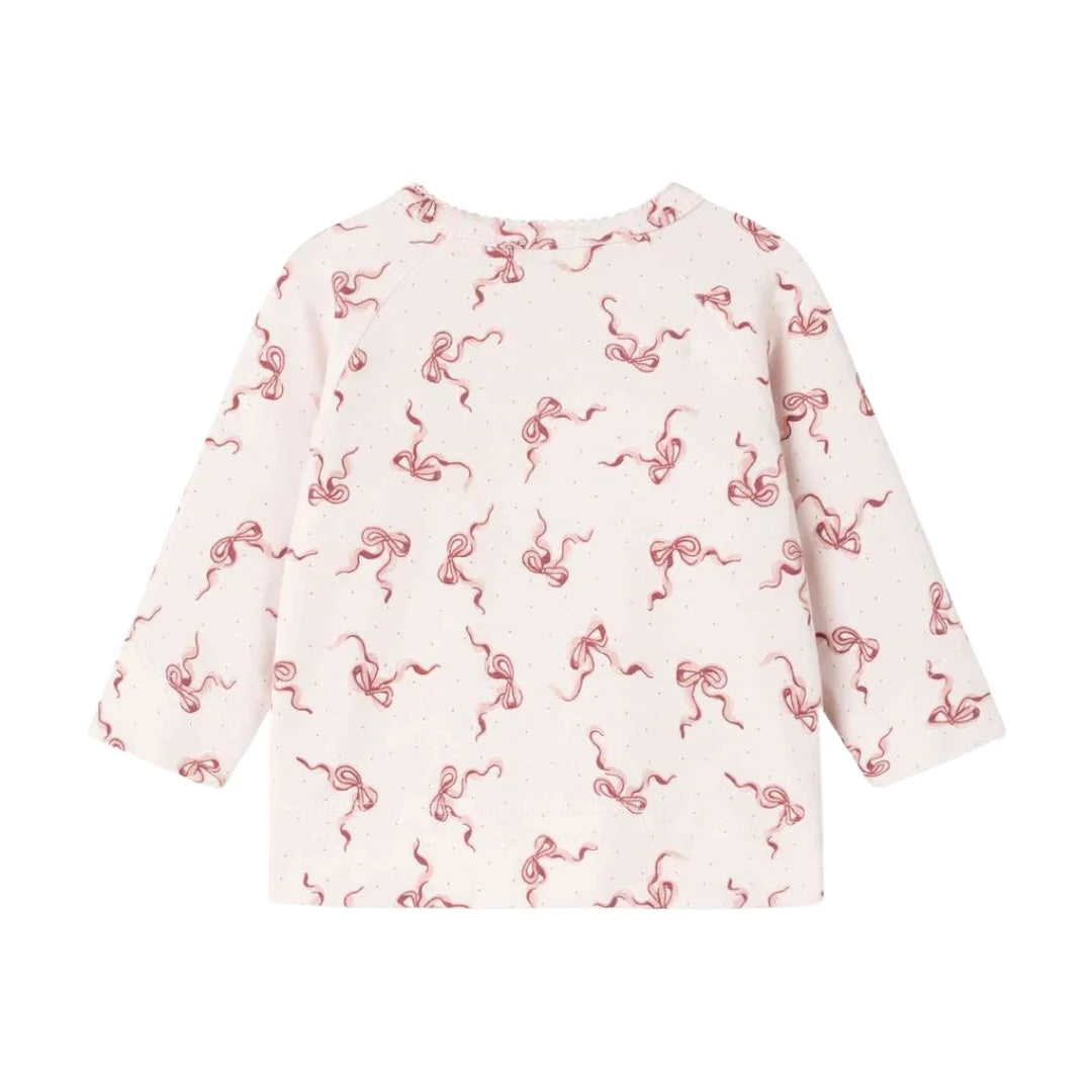 A front view of the organic cotton pink footed romper with bow pattern back