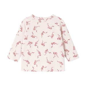 A front view of the organic cotton pink footed romper with bow pattern back