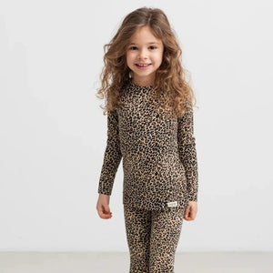 A child wearing the MarMar Copenhagen leopard tee and legging set comfortably during an outdoor playground outing.