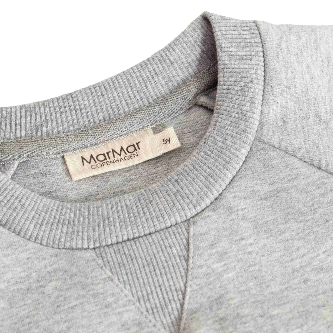 A high-resolution close-up of the plush fleece texture, collar, and signature logo detail.