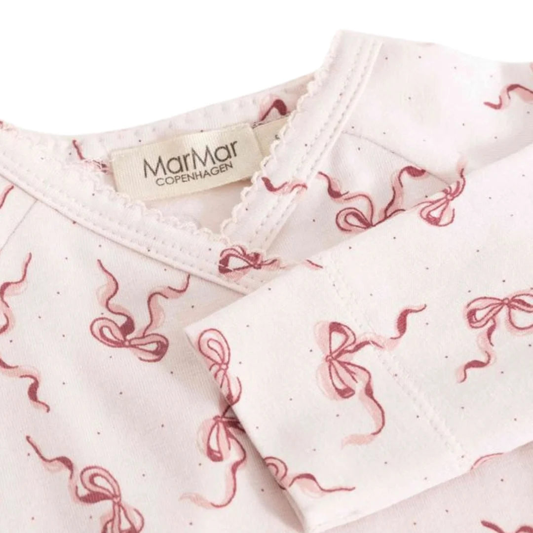A high-resolution close-up of the organic cotton knit texture and signature bow print.