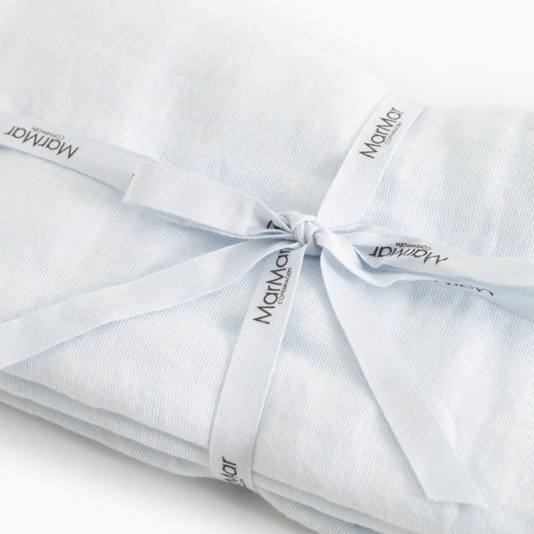 A folded light blue baby blanket or swaddle tied with a matching ribbon printed with the brand name 'Mammoth'.