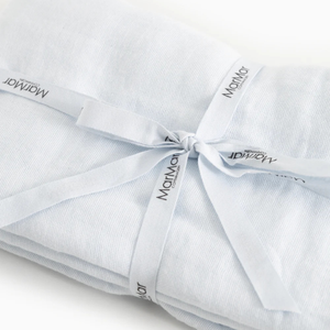 A folded light blue baby blanket or swaddle tied with a matching ribbon printed with the brand name 'Mammoth'.