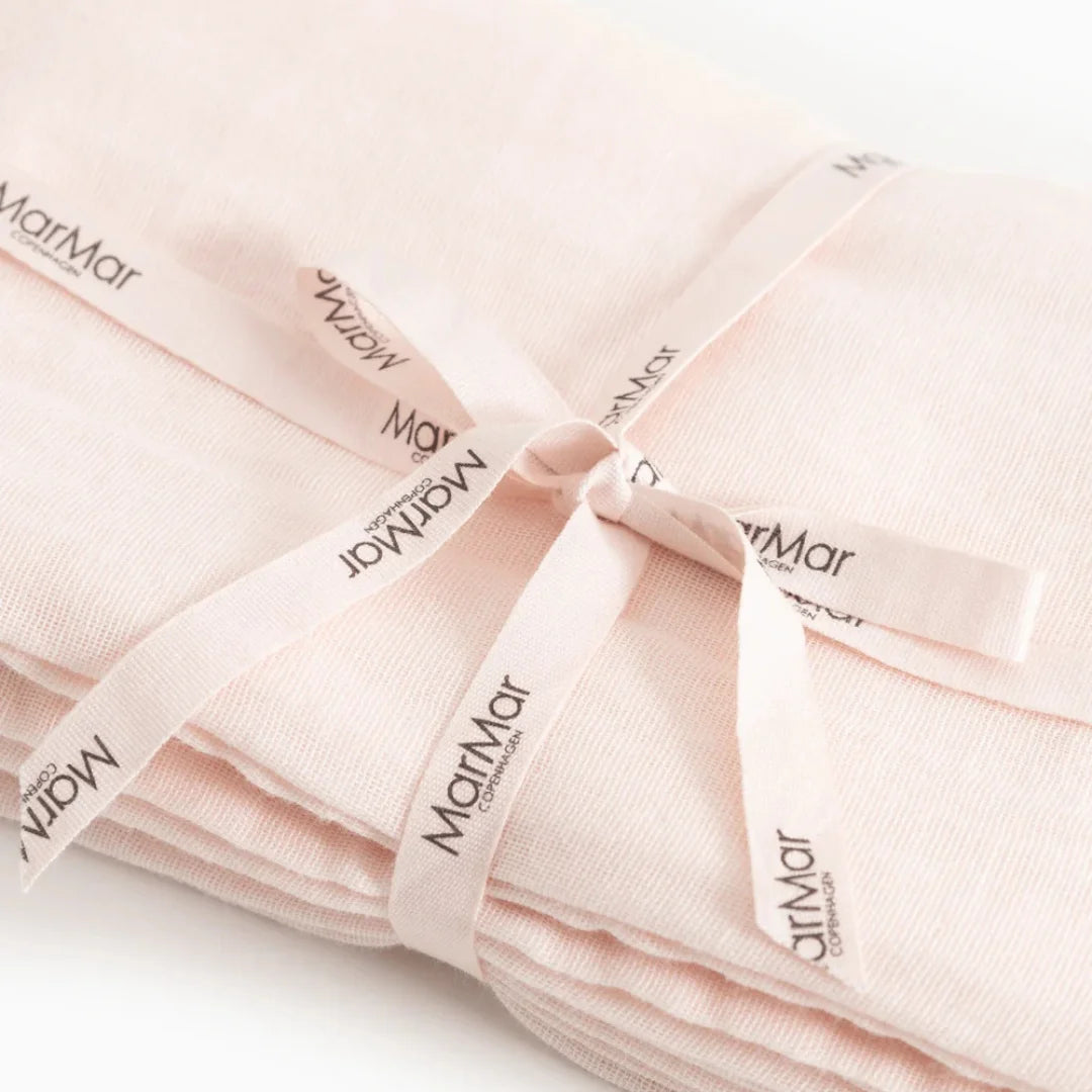 A folded light pink fabric item tied with a matching ribbon printed with the brand name 'Matrimony'.