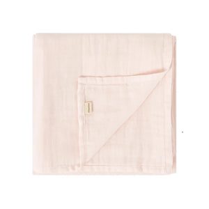 A folded light pink muslin blanket with a small beige brand tag, shown on a plain white background.