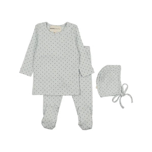 A baby sleepwear set by mema knits, featuring a long-sleeve footed sleeper and matching leggings in a light sage green with a small black polka dot pattern, accompanied by a matching bonnet.