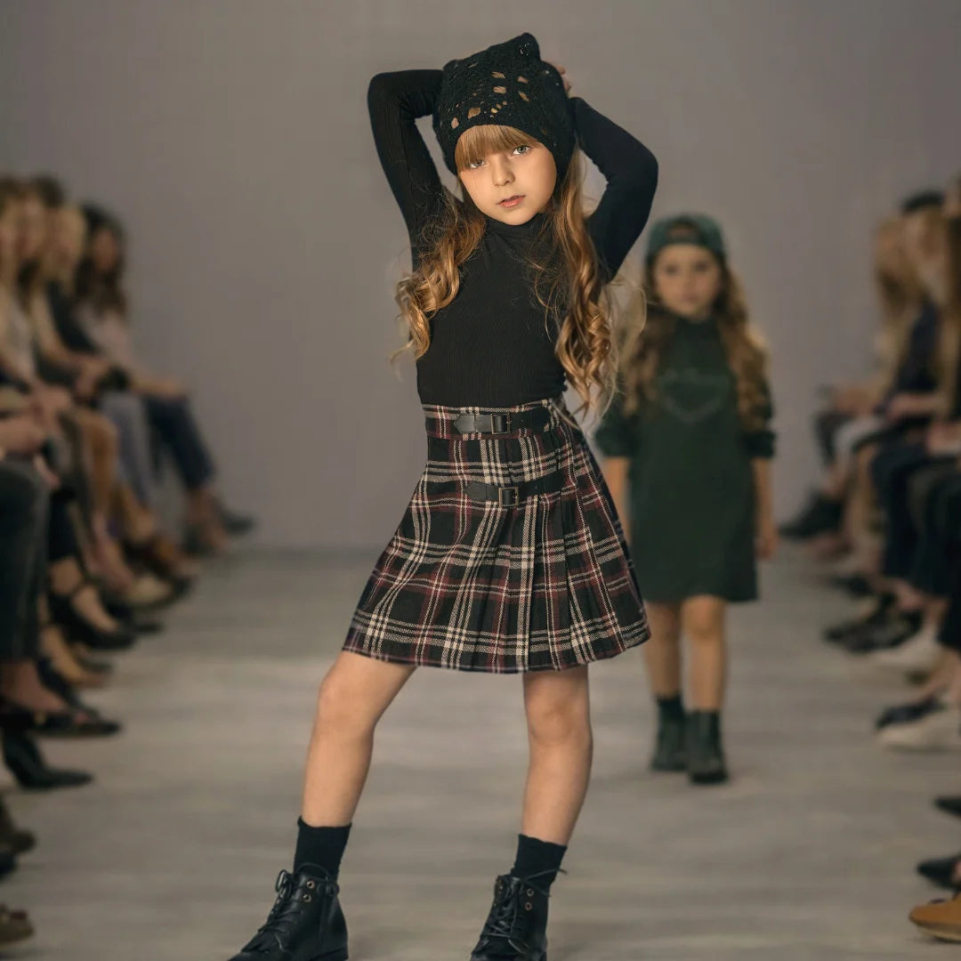 A young girl wearing the Mode Avant burgundy skirt during a runaway.