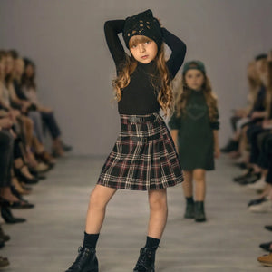 A young girl wearing the Mode Avant burgundy skirt during a runaway.
