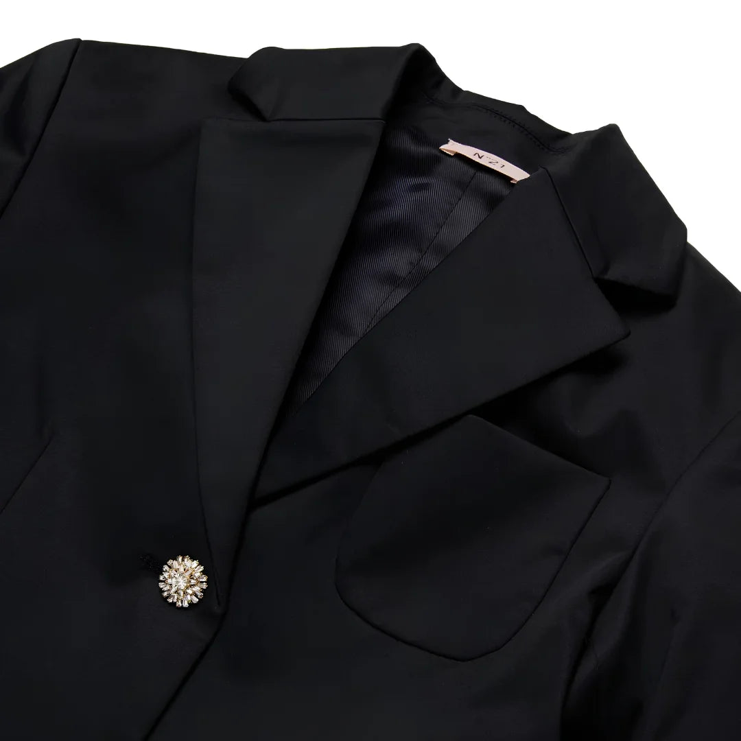 A close-up of the decorative embellished buttons and logo patch on the N°21 Kids blazer.