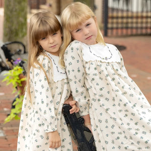 Childrens wearing the Nou Nelle cream corduroy floral dress during an autumn outdoor portrait session.