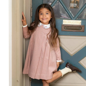 A child wearing the Nou Nelle pink houndstooth dress.