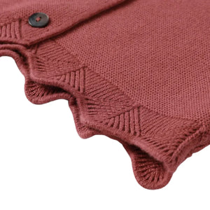 A high-resolution close-up of the fine knit yarn texture and scallop trim details.