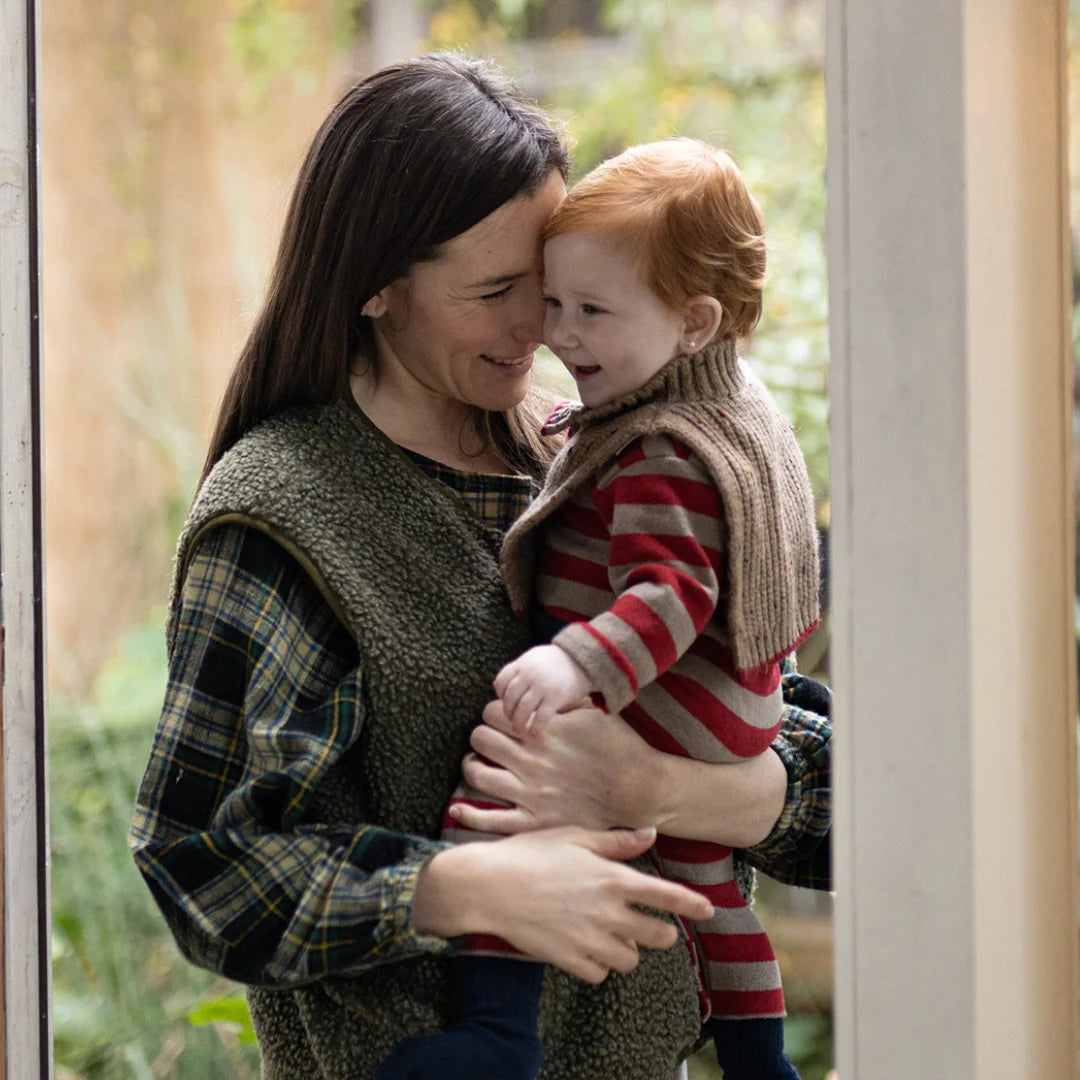 Woman holding a child in a garden setting