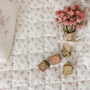 A high-resolution close-up of the delicate rose blossom print and soft cotton texture.