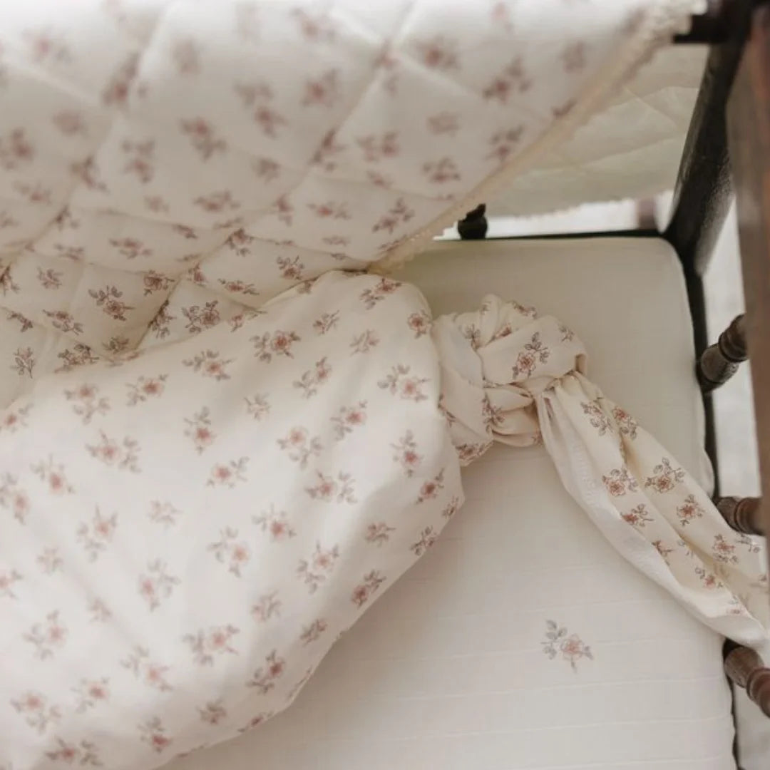A high-resolution close-up of the delicate rose blossom print and soft cotton muslin texture.