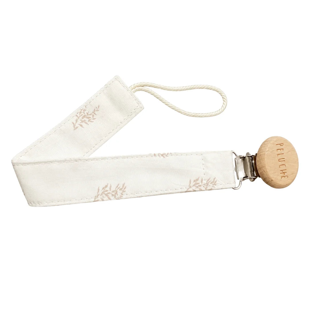 A front view of the Peluche Bebe taupe botanical pacifier clip.