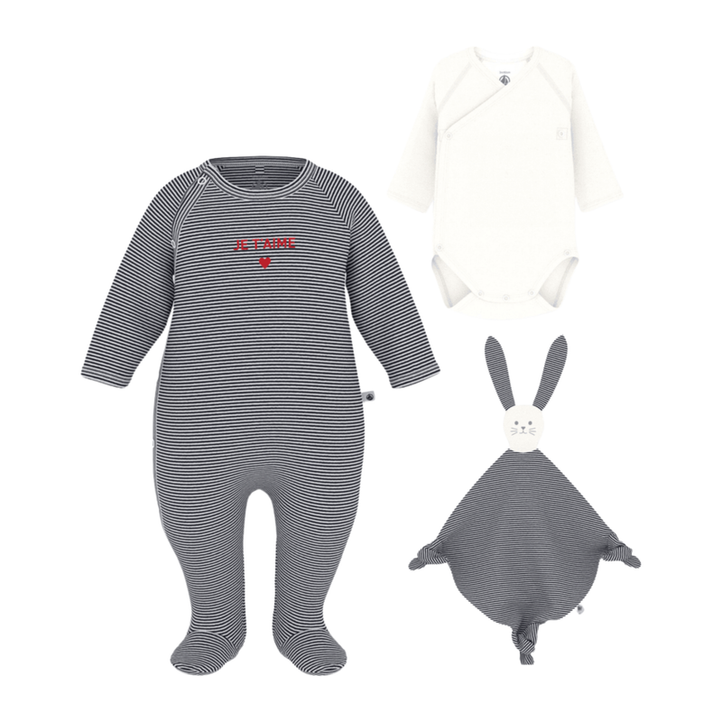 A front view of the Petit Bateau three-piece newborn set, including iconic stripe-print footie, white bodysuit, and soft doudou.