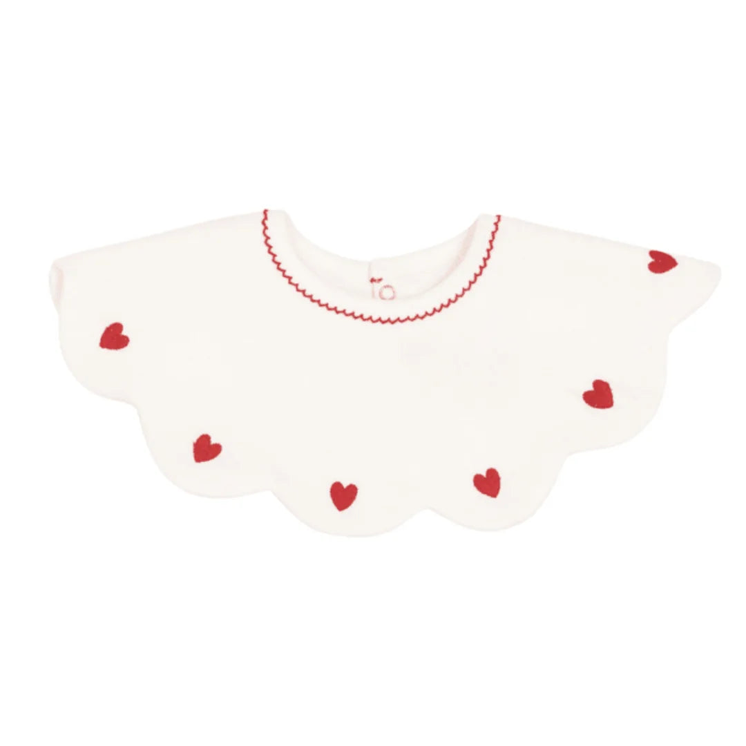 A breathtaking Petit Bateau baby girl bib featuring an immaculate white palette and a delicate heart detail for elegant everyday protection.